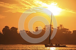 Felucca boat sailing on the Nile river at sunset, Luxor