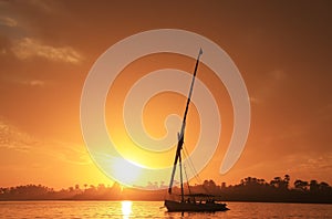 Felucca boat sailing on the Nile river at sunset, Luxor