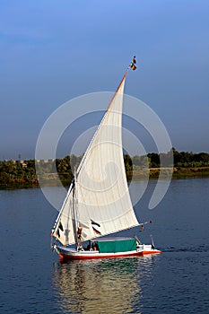 Felucca with white sails, sailing along the Nile River - Egypt