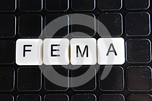 Fema control text word title caption label cover backdrop background. Alphabet letter toy blocks on black reflective background. photo