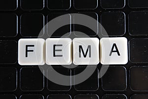 Fema title text word crossword. Alphabet letter blocks game texture background. White alphabetical letters on black