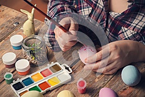 Femail hands holding paintbrush and easter egg