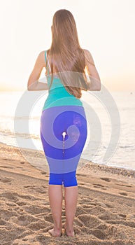 Female 20-25 years old is standing and practicing meditation in blue T-shirt