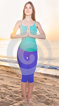 Female 20-25 years old is standing and practicing meditation in blue T-shirt
