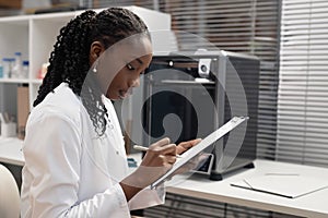 Female 3D Printer Engineer Writing on Clipboard