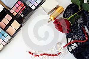 Female accessories, jewelry, perfume bottle, gift, pearls, red rose on a white background.