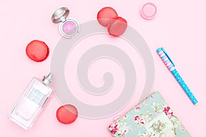 Female accessories and strawberry macaroons on a pink backgroun