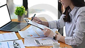 Female accountant analyzing financial reports at office desk.