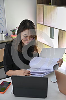 Female Accountant checking reports at office.