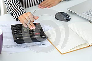 Female accountant hand holding silver pen