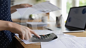 Female accountant hand makes calculations, closeup bills and calculator