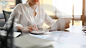 Female accountant using a calculator, checking and calculating a sales accounts