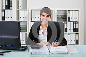 Female Accountant Writing On Documents