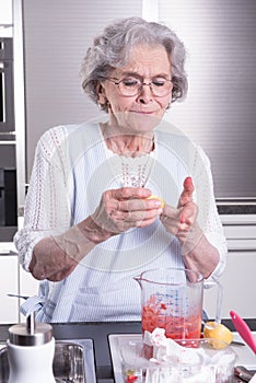 Female active pensioner is preparing strawberries