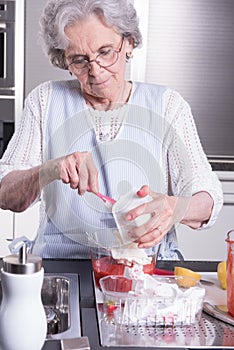 Female active pensioner is preparing strawberries