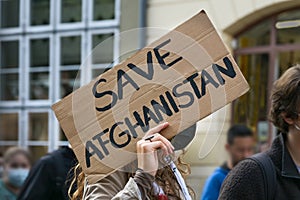 Female activist holding a cardboard sign with text Safe Afghanistan at a demonstration in Lubeck, Germany after the Taliban photo