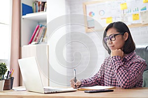 Female administrative assistant checking report on laptop