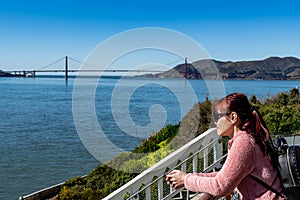 Female adult while enjoying the skyline view of San Francisco USA and Golden Gate Bridge from Viewing Deck in Alcatraz Island