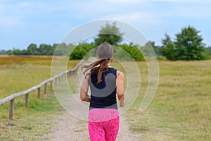 Female adult jogger running away from camera
