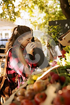 Female adult smells bio apple in market