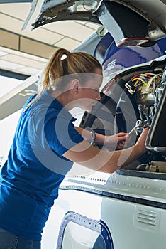 Female Aero Engineer Working On Helicopter In Hangar