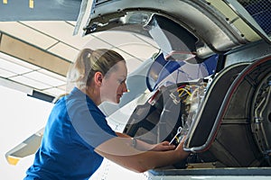 Female Aero Engineer Working On Helicopter In Hangar photo
