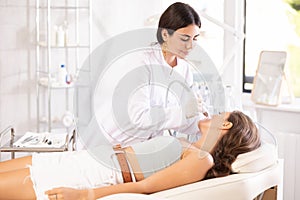 female aesthetician making facial skin cleaning