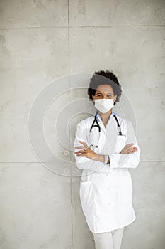 Female African American doctor wear white uniform and protective facial mask