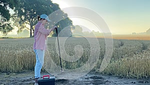 Female agronomy specialist preparing to examine soil at sunrise