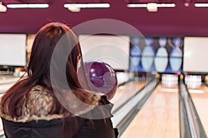 Female while aiming towards pins in a bowling game. Competitive bowling by a female while aiming to the target