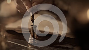 Female in antique outfit writes with feather pen. Close up shot of woman dipping vintage quill feather pen in golden