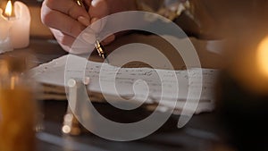 Female in antique outfit writes with feather pen. Close up shot of woman writing a letter with vintage quill on old