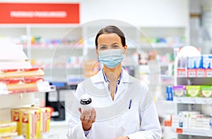 Female apothecary in mask with drug at pharmacy