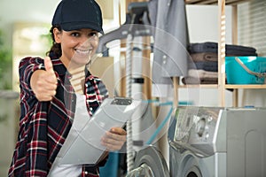 female appliance technician showing thumbs up