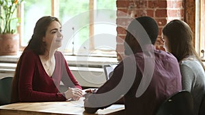 Female applicant talking during job interview with multiracial hr managers