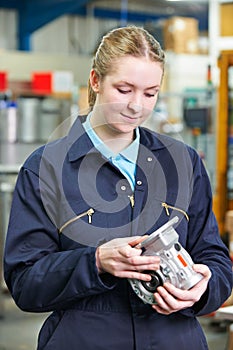 Female Apprentice Engineer Checking Component