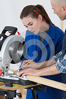 Female apprentice learning to use circular saw