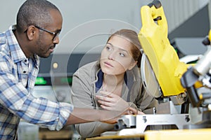 female apprentice learning to use circular saw