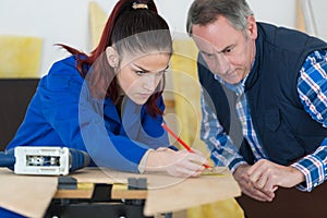 female apprentice with pencil and wood in hands