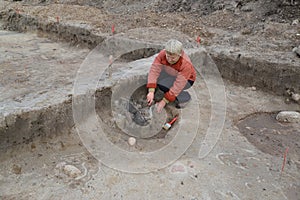 The female archeologist works at excavation with the ancient center