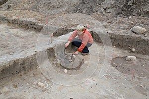 The female archeologist works at excavation with the ancient center