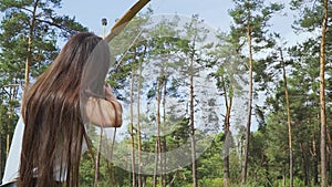 Female archer launches arrow into the sky