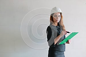 Female architect at the construction site with drawings and note