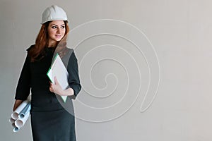 Female architect at the construction site with drawings and note