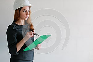 Female architect at the construction site with drawings and note