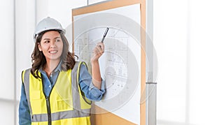 Female Architect engineer presenting her construction plan on blackboard in a business meeting