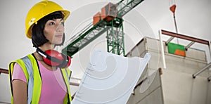 Composite image of female architect holding blueprint against white background