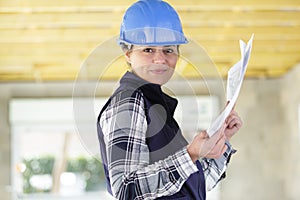 Female architect holding plans in property