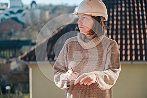 Female architect making notes and remarks during building site inspection