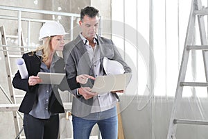 Female architect and male engineer to work in consultation computer to plan the project, Inside the construction site. House buy